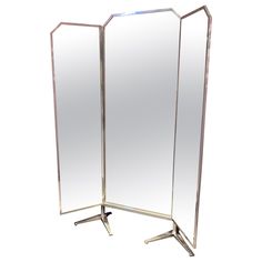 a tall mirror standing on top of a metal stand