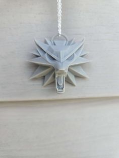 a necklace with a wolf head hanging from it's side