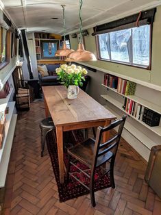 a dining table in the middle of a room with bookshelves on either side