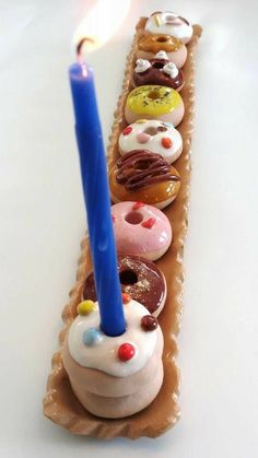 a long row of doughnuts with a lit candle