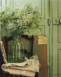 a vase filled with white flowers sitting on top of a table next to a book