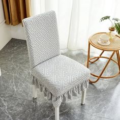 a chair that is sitting on the floor next to a table with a potted plant