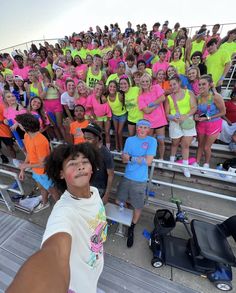 a group of people standing next to each other in front of a bleachers