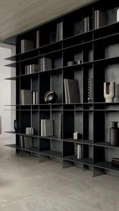 a large bookcase with many books on it in a room that has concrete floors