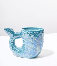 a blue glass cup sitting on top of a white table