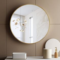 a round mirror sitting on top of a counter next to a white vase and lamp