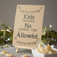 a sign that says kids corner no grown ups allowed next to some nuts on a table