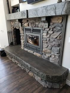 a stone fireplace with a tv above it