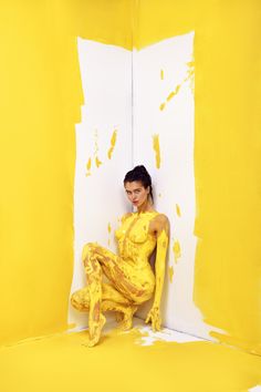 a woman sitting on the floor in yellow paint