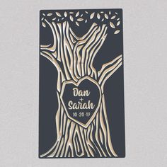 the laser cut wedding card features a tree with leaves and a heart in its center