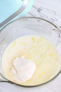 a glass bowl filled with batter next to an electric mixer on a wooden counter top