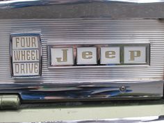 an old jeep with four wheels and the word jeep spelled in metal letters on it