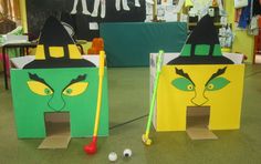 two cardboard houses with faces painted on them, one has a golf ball in it