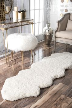 a living room with white fur rugs on the floor