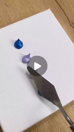 a piece of paper that has been cut into blue and purple shapes with a knife