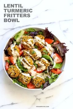 a white bowl filled with meatballs and salad on top of a marble countertop