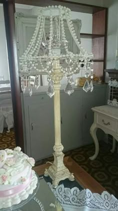 a table with a cake on it and a chandelier in the corner behind it