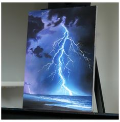 an easel with a painting of a lightning storm on it