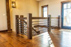 an empty room with wood floors and railings in the center, next to a large open door