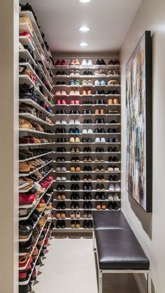 a walk in closet with lots of shoes on the shelves and a bench next to it