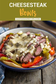 a beef sandwich with cheese and peppers in a blue bowl on top of a wooden table