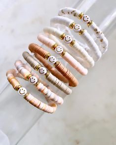 a stack of bracelets with smiley faces on them sitting in front of a glass vase