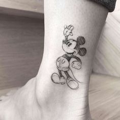 a small mickey mouse tattoo on the ankle