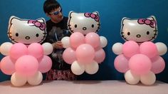 hello kitty balloons are being held in front of a man