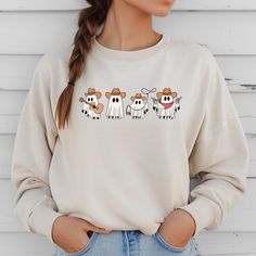 Stay cozy and stylish in our Cowboy Ghosts Sweatshirt. This western-inspired sweater features cute ghost designs that will add a playful touch to your wardrobe. Get ready to turn heads and keep warm in our unique and fun sweatshirt. Fall Cartoon Print Tops For Loungewear, Casual Fall Sweatshirt With Cartoon Print, Casual Fall Cartoon Print Sweatshirt, Fall Character Print Relaxed Fit Sweatshirt, Funny Print Long Sleeve Sweatshirt For Fall, Long Sleeve Sweatshirt With Funny Print For Fall, Trendy Fall Sweatshirt With Character Print, Trendy Character Print Sweatshirt For Fall, Fun Fall Loungewear Tops