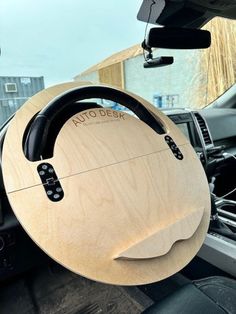 the steering wheel cover is made out of wood and has black stitching on it