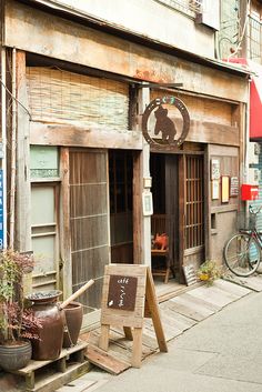 an old building with a sign in front of it on the side of a street