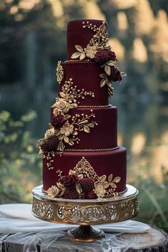 a three tiered red wedding cake with gold flowers