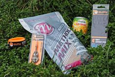 an assortment of sports items laying in the grass next to some toothpaste and bracelets