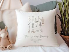 the birth pillow is next to a stuffed animal and potted plant in front of it