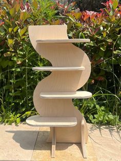 a three tiered wooden shelf sitting on top of a sidewalk