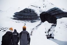 two snowboarders standing in front of a mountain