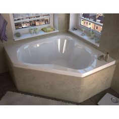 a bath tub sitting next to a window in a bathroom