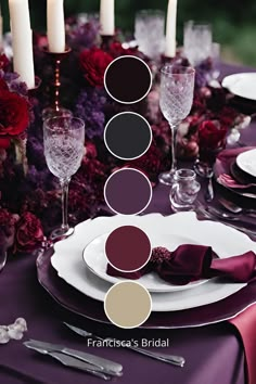 the table is set with white plates, silverware and red flowers in shades of purple