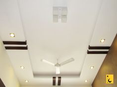 an empty room with white walls and ceiling fan