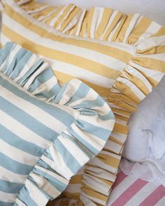 three pillows with ruffled edges on top of each other in different colors and patterns