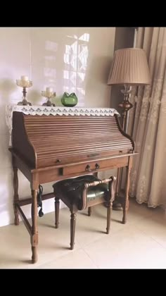 an old wooden piano sitting in front of a lamp