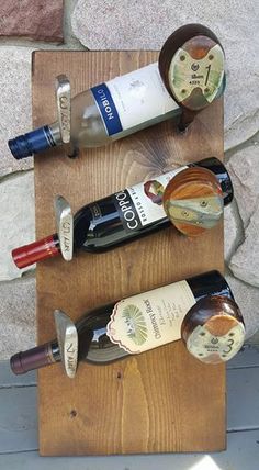 three bottles of wine sitting on top of a wooden table next to a bottle opener