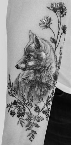 a black and white photo of a fox with flowers on it's arm,