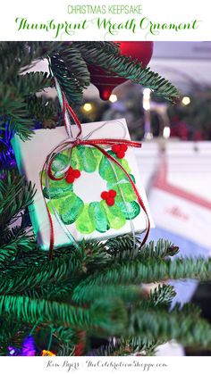 an ornament hanging from a christmas tree decorated with green leaves and red berries