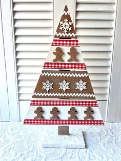 a christmas tree made out of wood with gingerbreads and snowflakes on it