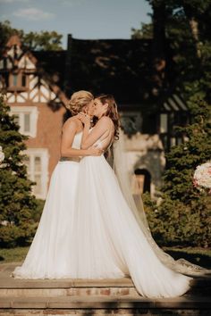 the bride and groom share a kiss in front of their home