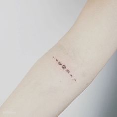 a woman's arm with three phases of the moon on it