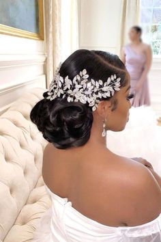 a woman in a wedding dress wearing a bridal hair comb with flowers on it