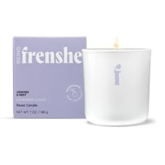 a white candle sitting next to a purple box on a white surface with the words freshness written in it