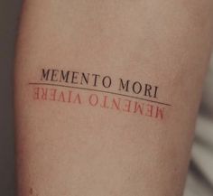 a woman's arm with the word mementoo mori tattooed on it